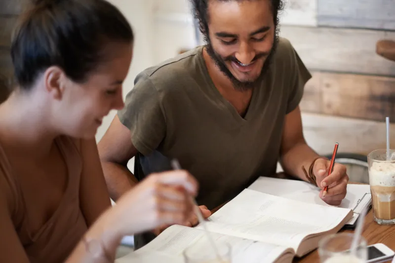 Two friends studying together at a table